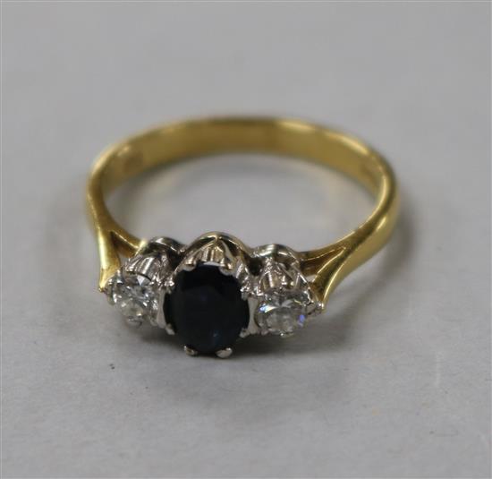 An 18ct gold, sapphire and diamond three stone set ring, size N.
